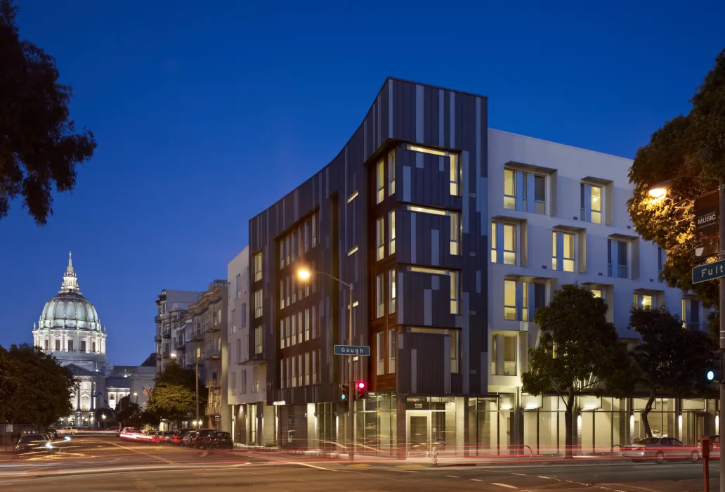 Night view of Richardson Apartments with City Hall dome in background in San Francisco.