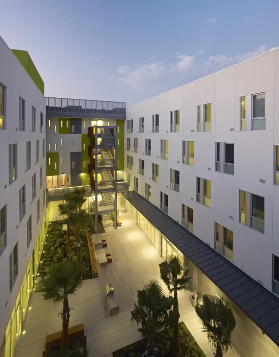 Dusk view of illuminated courtyard at Richardson Apartments in San Francisco.