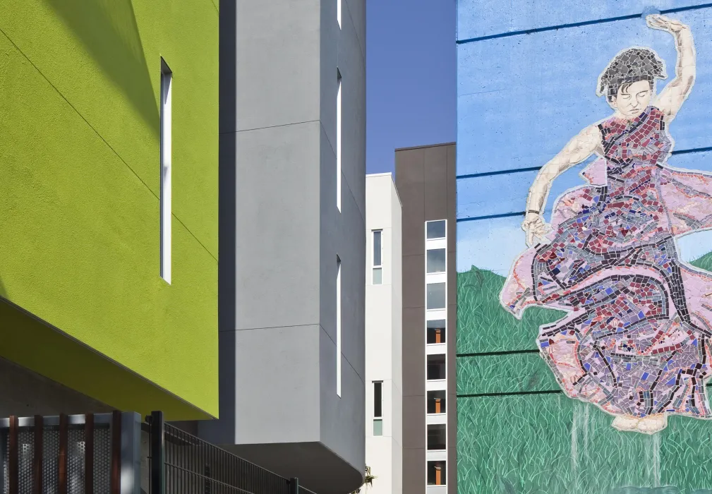 Detail of mural and green, gray, and white stucco bays at Richardson Apartments