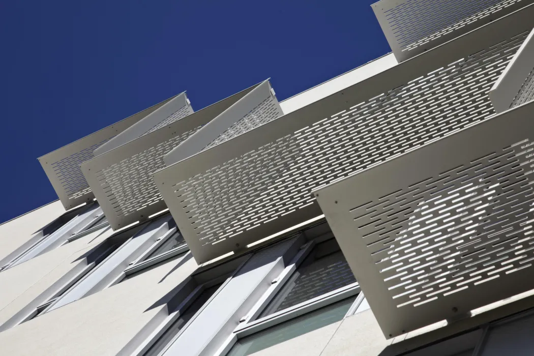 Detail of aluminum sunshades on white stucco bay at Richardson Apartments in San Francisco.