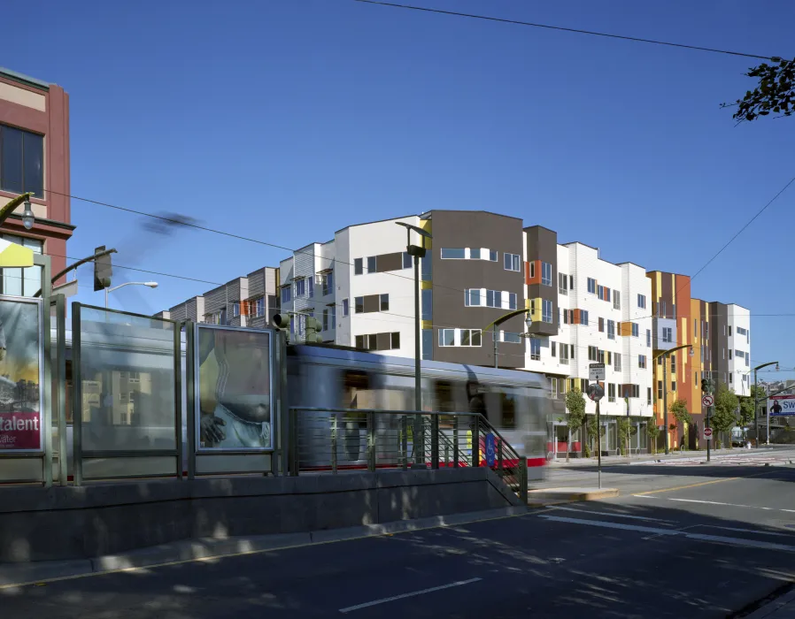 A senior apartment building with a train stop in the foreground, showing proximity to transit. 