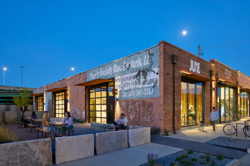 View of the multiple people enjoying the open courtyard at dusk at the Bandsaw Building in Birmingham, Alabama.