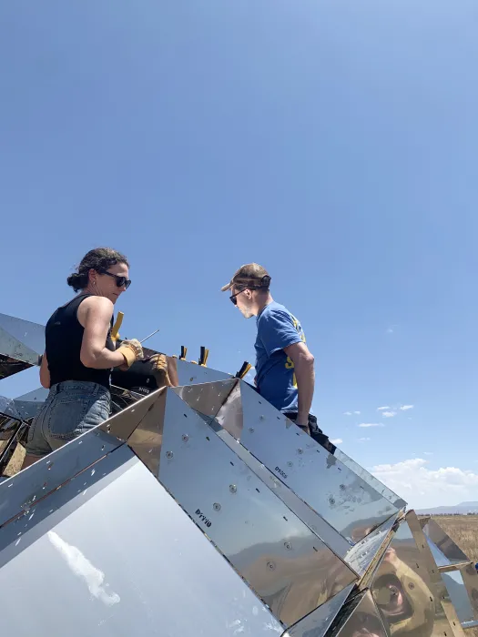 A man and a woman building peepSHOW with blue skies in New Cuyama, California