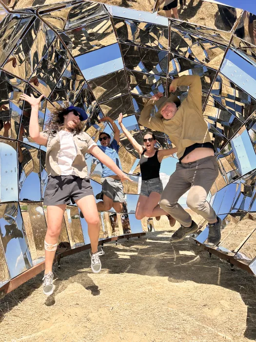 A group of people in jumping up inside peepSHOW in the desert in New Cuyama, California.