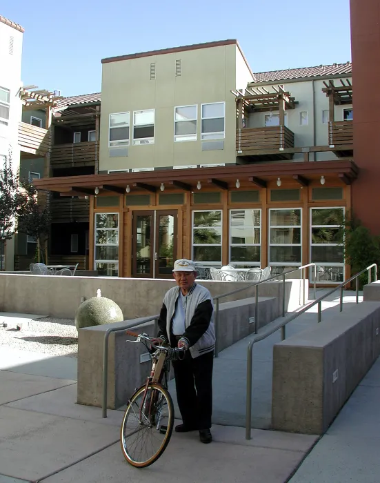 Man walking his bike at the courtyard of Mabuhay Court in San Jose, Ca.