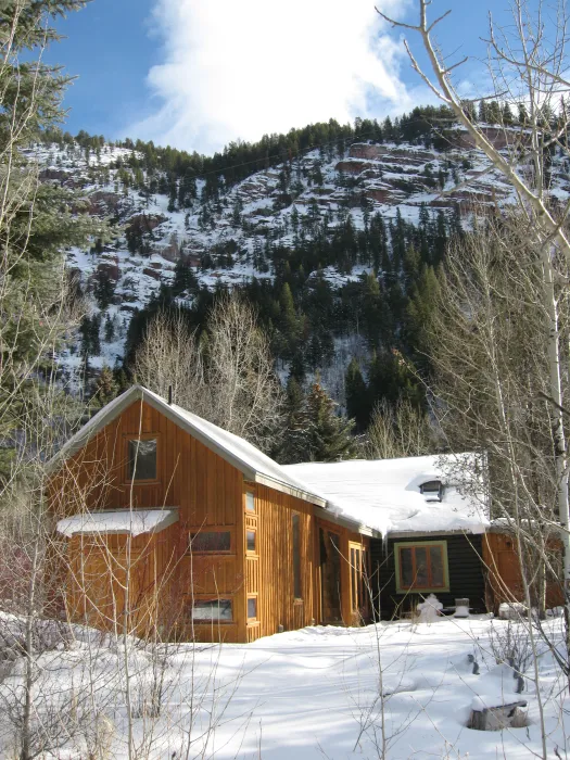 Exterior rear view of Redstone Cabin covered in snow in Redstone Colorado.