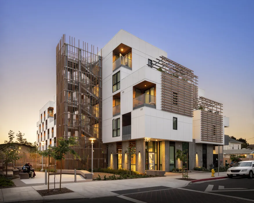 Exterior view of Page Street Studios at dusk with resident windows illuminated in San Jose, California. 