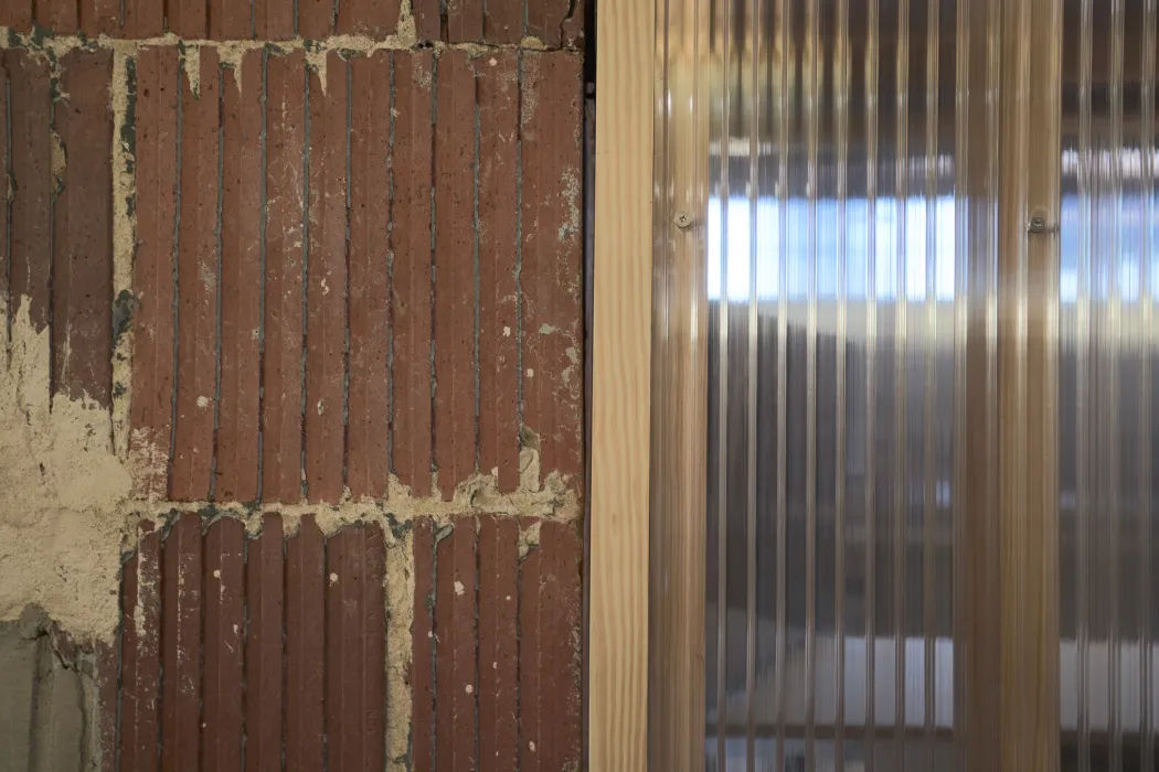 Detail of exposed terracotta and translucent double-walled polycarbonate panels at Wyatt Builds office. 