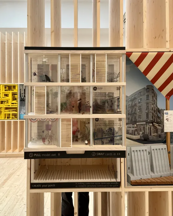 Model on display in a plywood pavilion