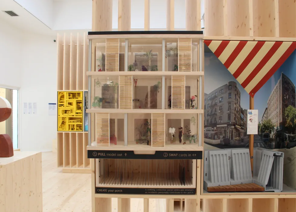 Model on display in a plywood pavilion.