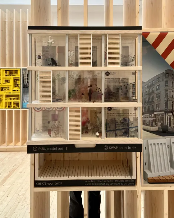 Model on display in a plywood pavilion.