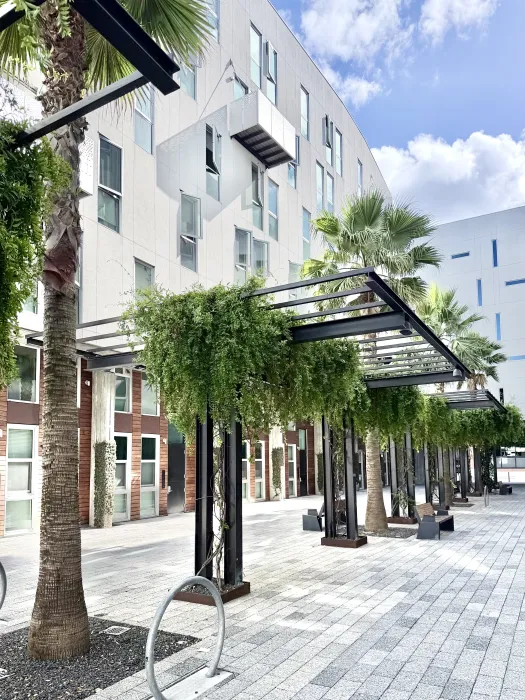 View of outdoor passage of white building against blue sky