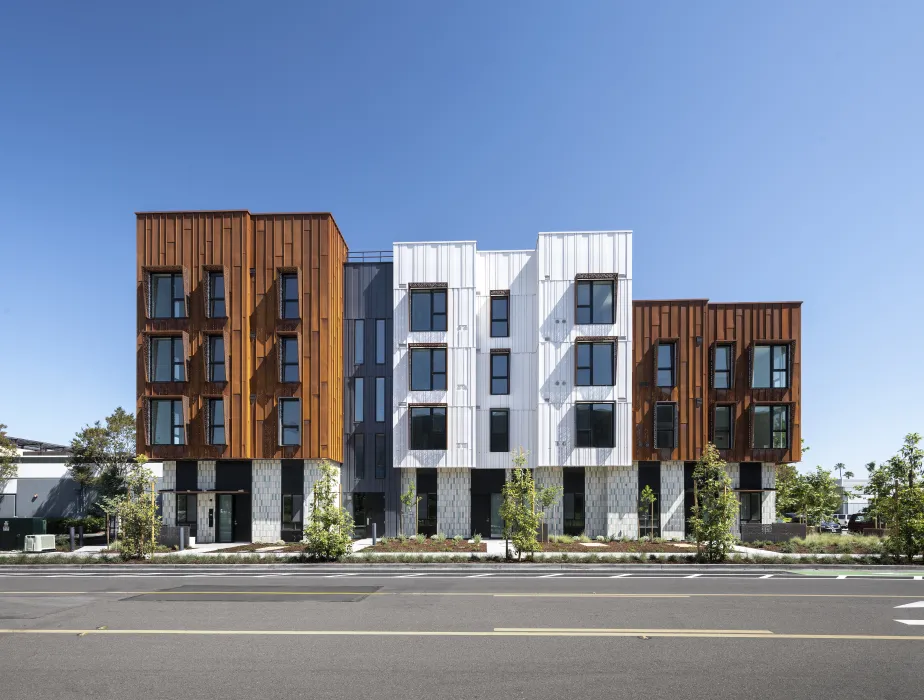 Elevation view of a modern building with rusted-steel and white volumes. 