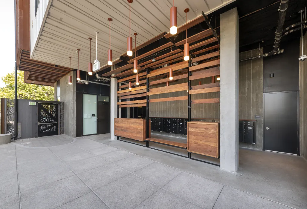 View of open-air lobby with lighting and mailboxes.
