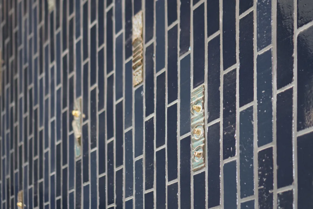Closeup view of blue tiled wall with custom textured highlight tiles