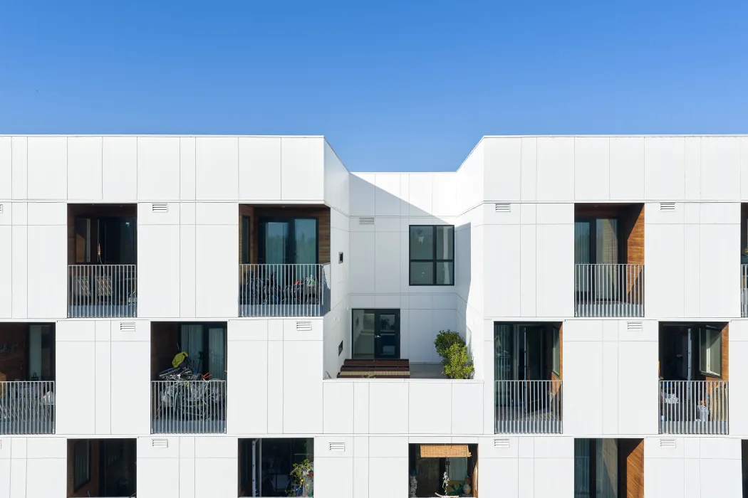 Close up of balconies in checkerboard pattern in white apartment building against blue sky