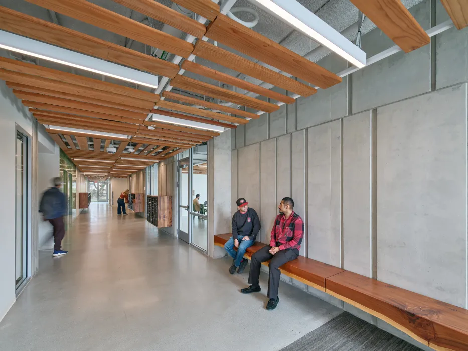 Entry hallway with wooden ceiling and benches against textured concrete walls