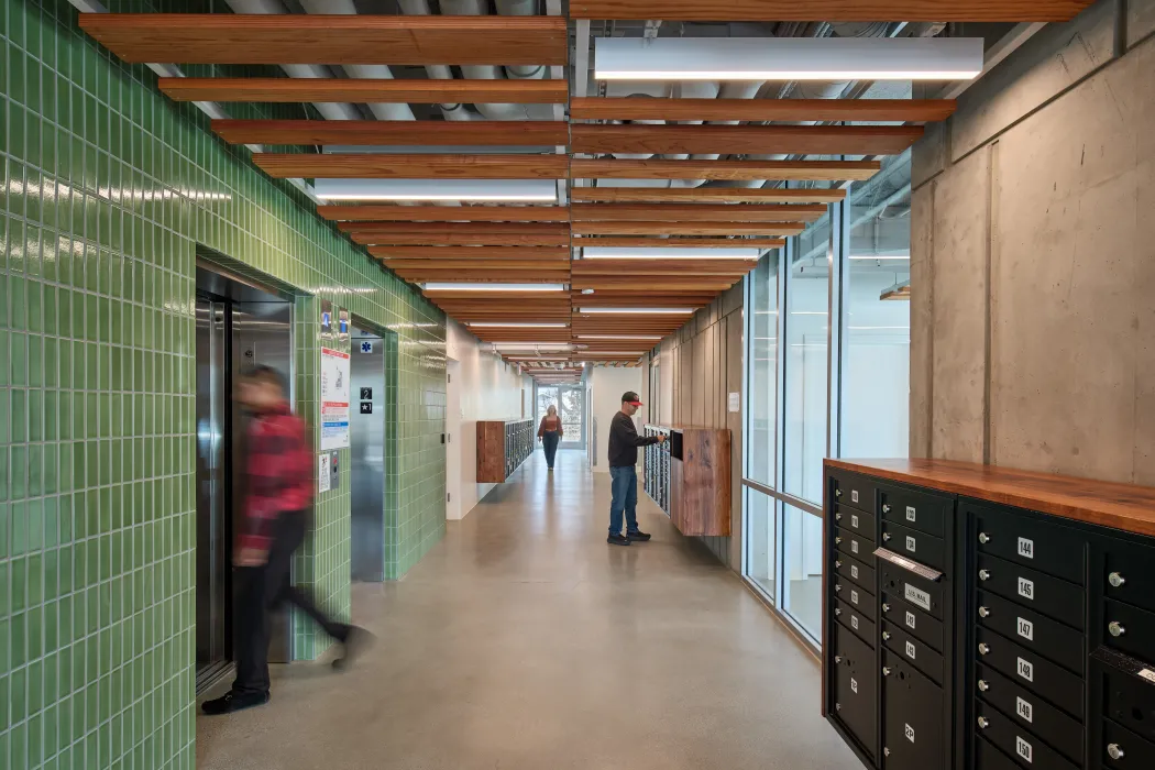 Entry lobby with green tile at elevators and banks of residential mailboxes