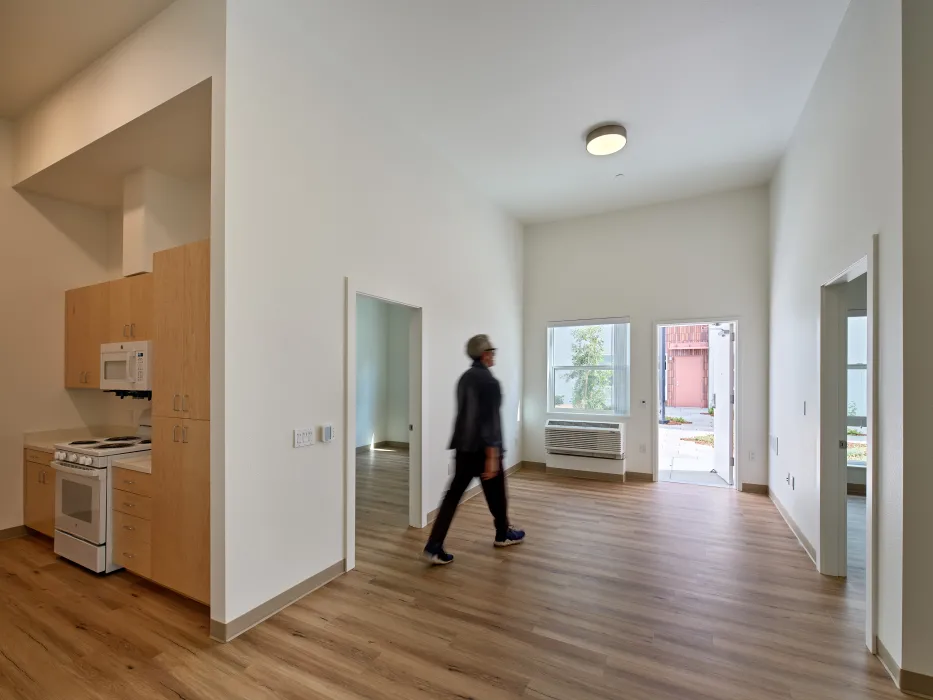 Man walking through empty apartment with very high ceilings