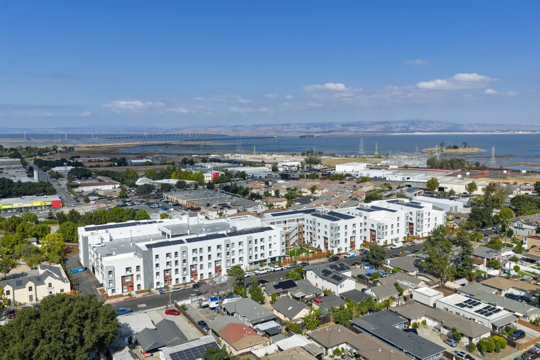 Oblique aerial view of large white building set in an urban context