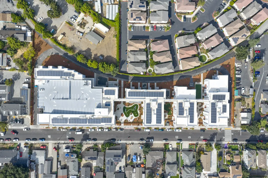 Aerial view of four building community along a curving rail spur.