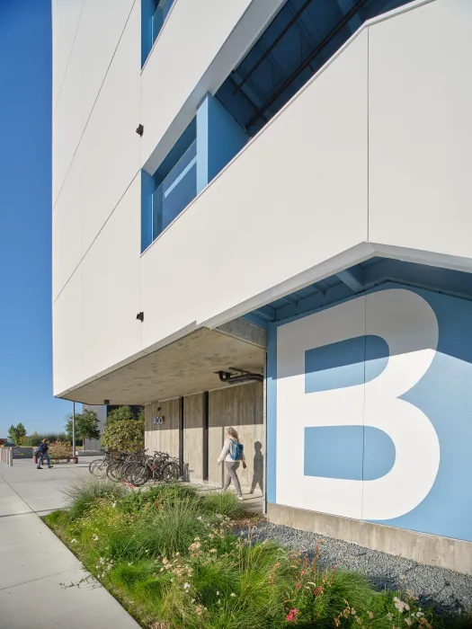 White building with white letter B on a light blue wall