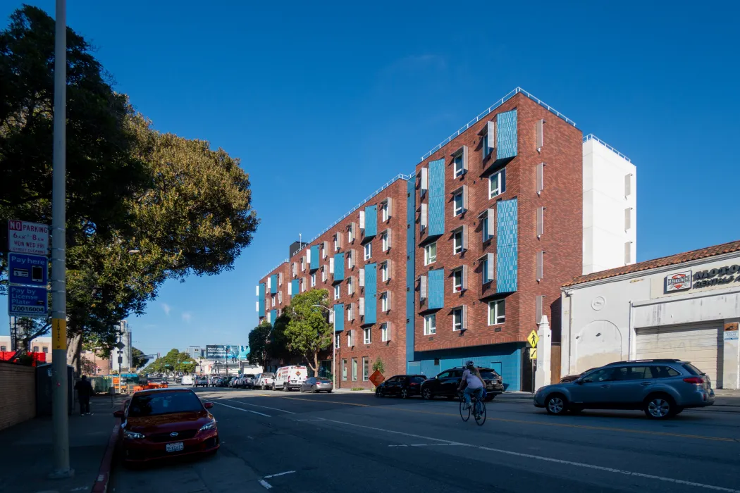 Street view of brick apartment building with blue accents