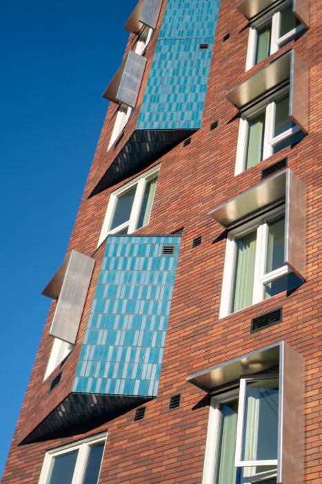 Exterior detail showing vibrant blue brick contrasting with terra-cotta-color brick