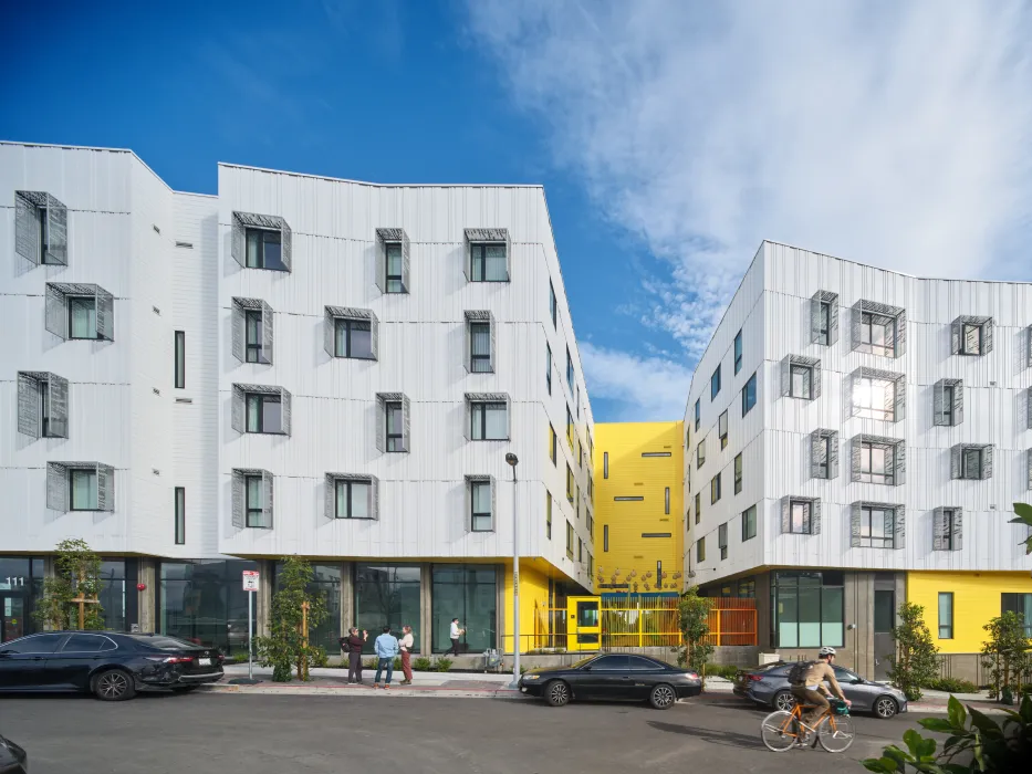 Street view of apartment building with cyclist in the foreground