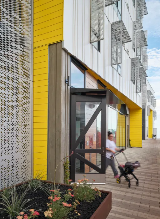 Woman with stroller exiting an apartment building