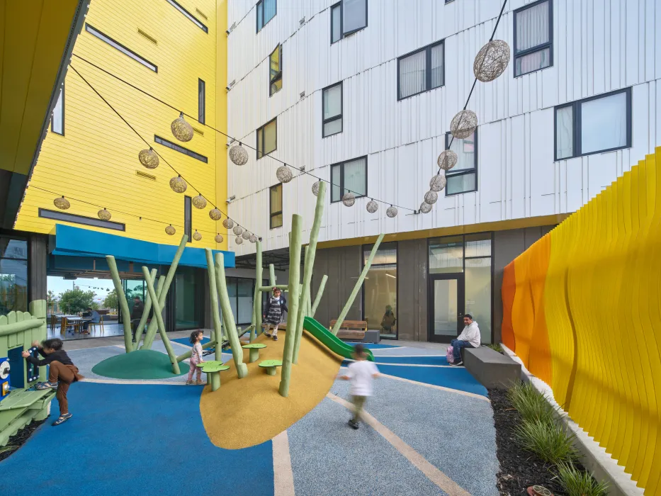 Children play on outdoor equipment in a courtyard
