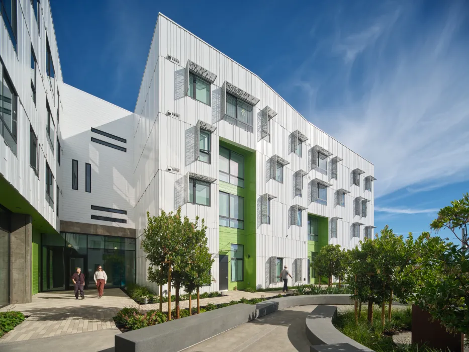 Exterior of white apartment building with green entry portals