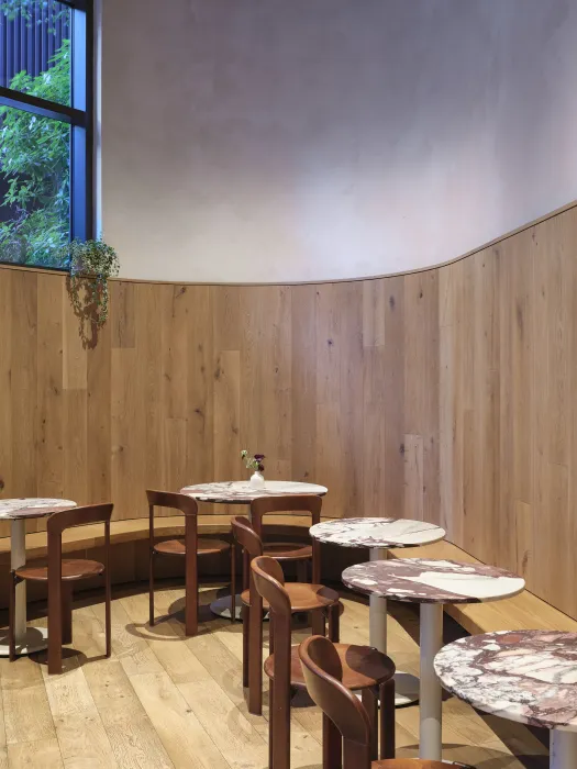 Bistro tables line a curved wall