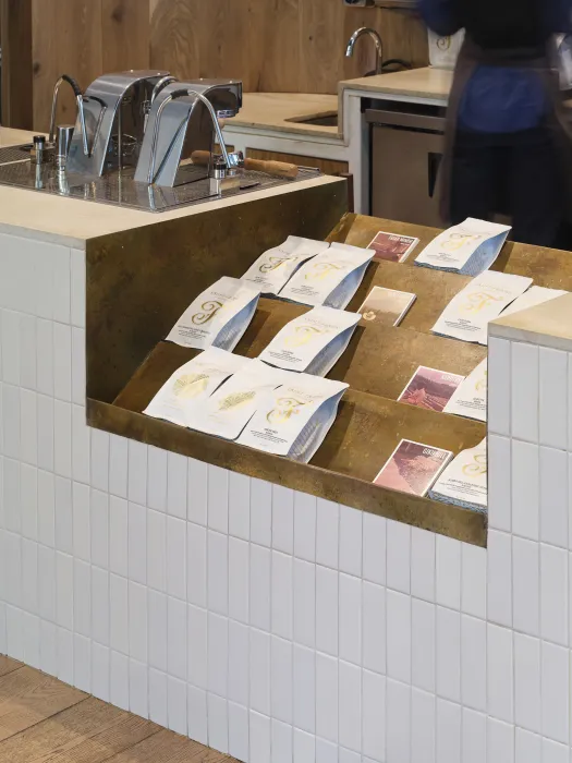 A cutout in the countertop serves as a display case for bags of coffee and other goods