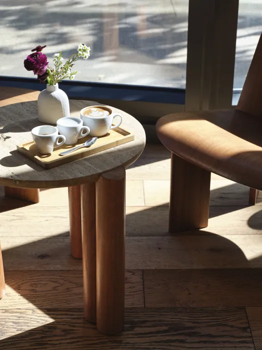 A trio of coffee drinks on a small table near the window