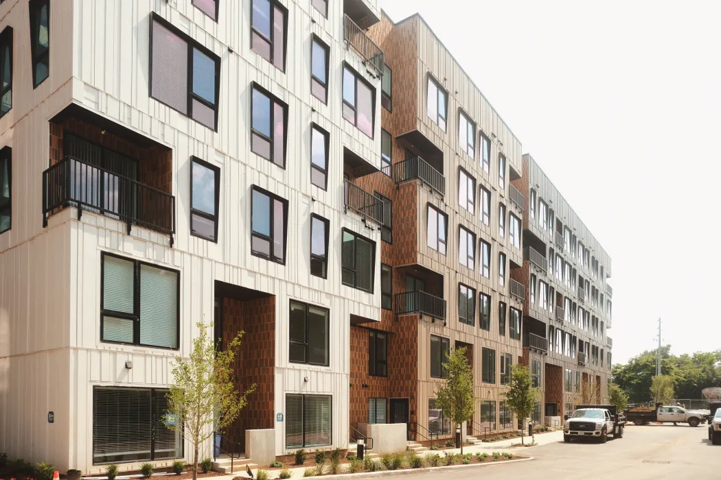White and rust colored building along a street