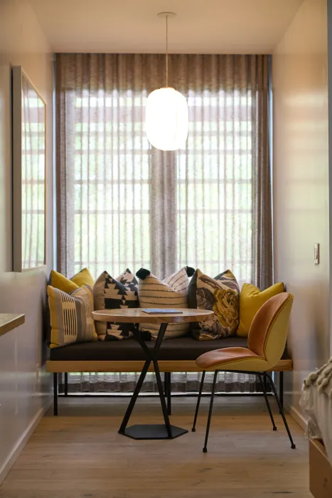 Room nook with built in bench and woven pillows in front of window