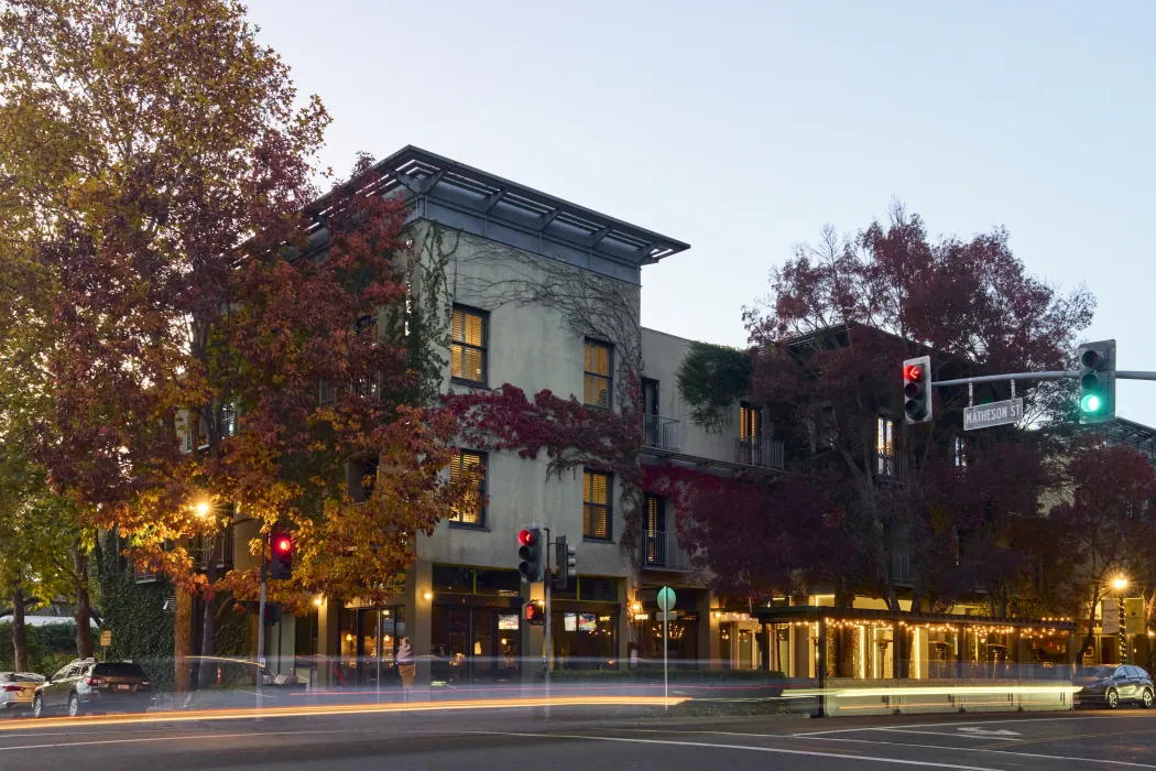 Dusk view of corner hotel with with fall trees