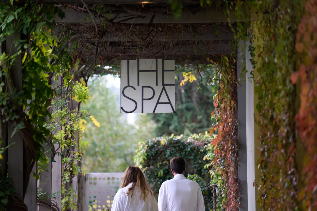Two people in robes walking under sign that says "The Spa"