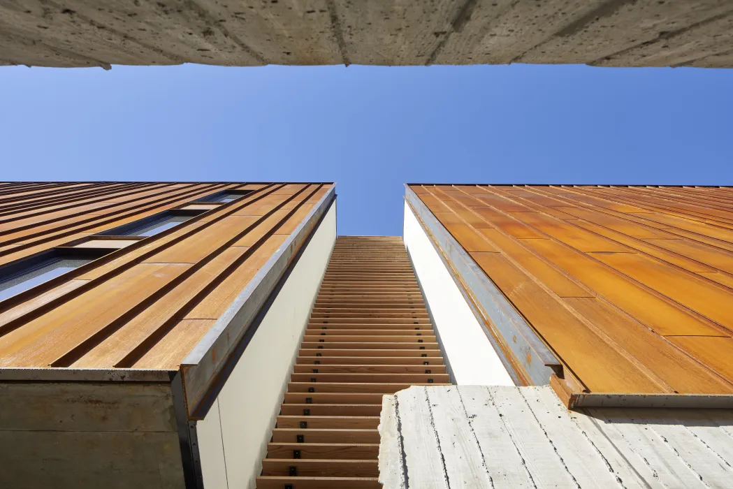 A view from below looking at the carefully curated wood slat pattern on Harmon Guest House's exterior.
